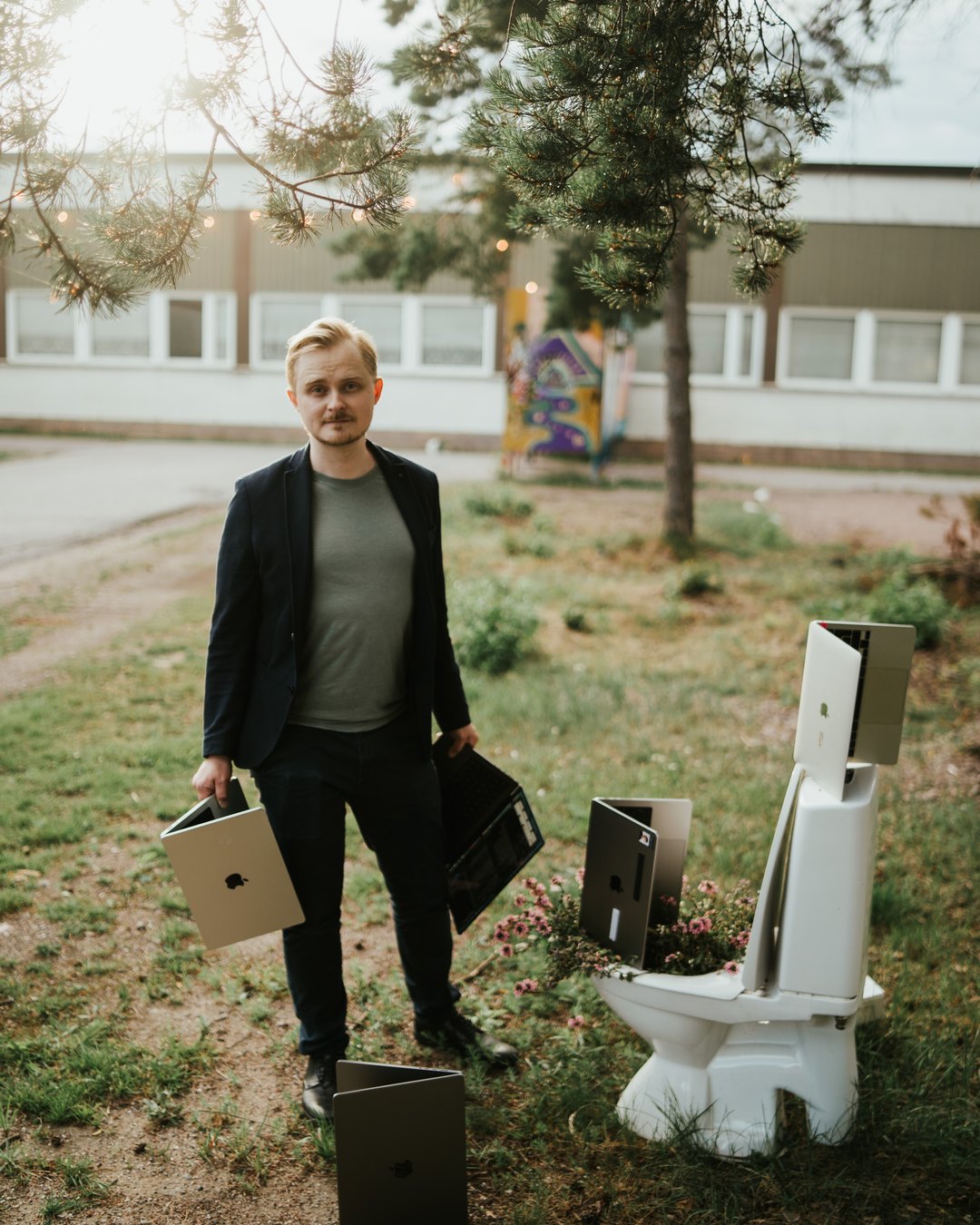 Markus Hav standing outdoors holding laptops